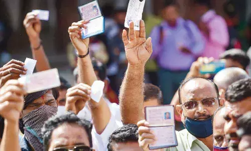 Stranded passengers display their tickets during BMTC and KSRTC employees strike against the State government in Bengaluru on Monday