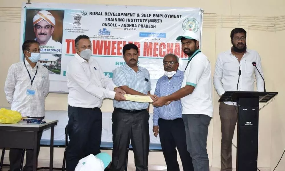 NABARD DDM Venkata Ramana presenting certificates to two-wheeler mechanics at RUDSETI in Ongole on Tuesday