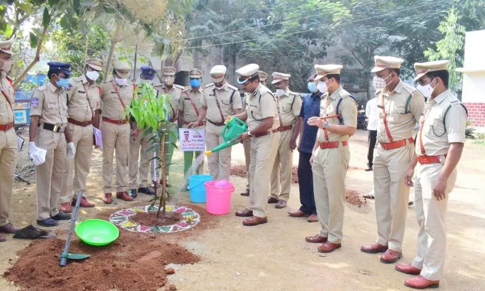 North Zone IGP Y Nagireddy watering a sapling after planting it on Nirmal rural police station premises on Tuesday