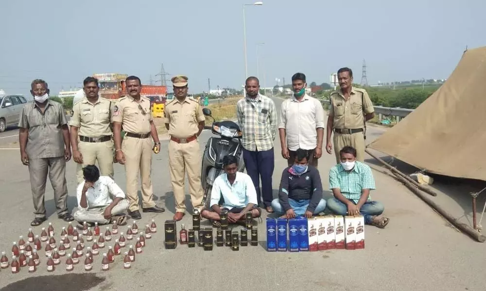 SEB Circle Inspector Lakshmi Durgaiah with the seized liquor at Panchalingala check post on Monday