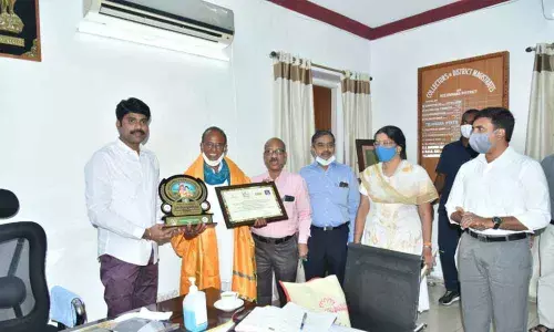 District Collector C Narayana Reddy along with Chinni Krishna, recipient of Rythu Nestam Award, at his chamber in Nizamabad on Monday