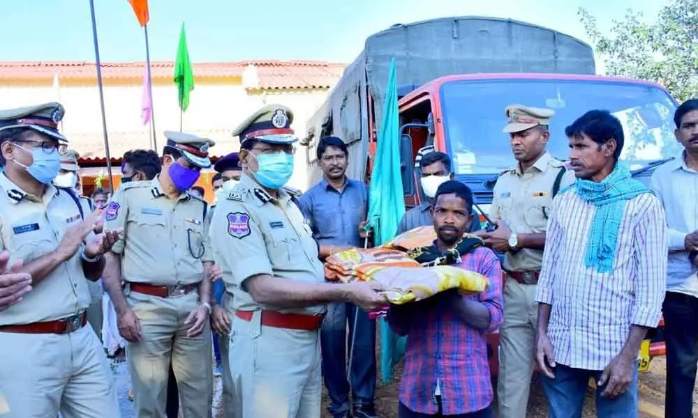 DGP M Mahender Reddy giving away a blanket to a Gothi Koya in Mulugu on Wednesday