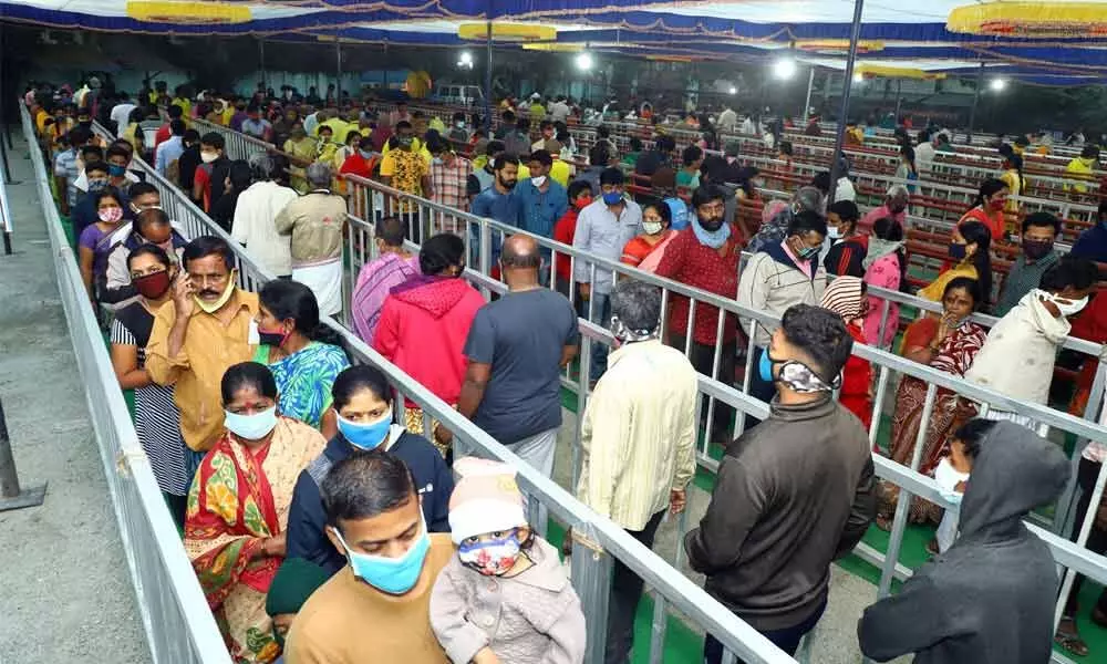 Large number of devotees stand in long queue lines for Vaikunta Dwara Darshan tickets at Municipal office in Tirupati on Thursday