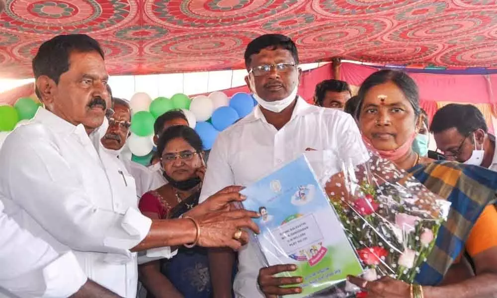 Deputy Chief Minister K Narayana Swamy handing over the house site pattas to a woman beneficiary at GD Nellore, in Chittoor  on Friday