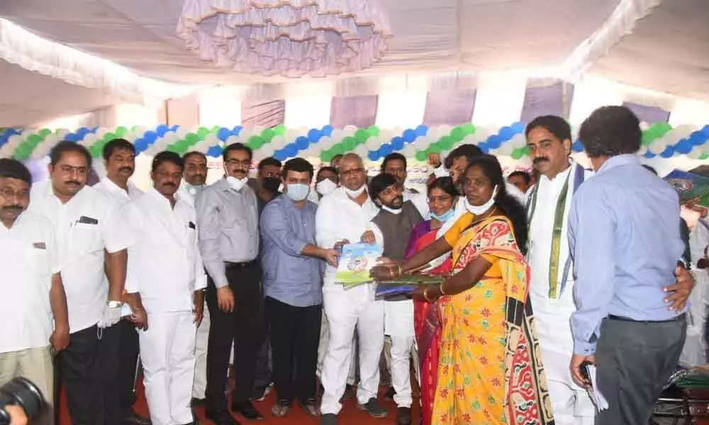 Tourism Minister Muttamsetti Srinivasa Rao distributing house site pattas to the beneficiaries in Visakhapatnam on Friday