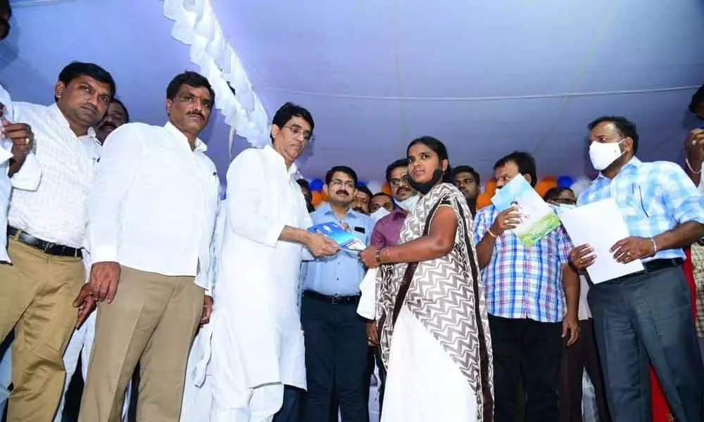 Finance Minister Buggana Rajendranath Reddy distributing house site pattas to the beneficiaries at government girl’s high school in Dhone town on Friday. Joint collector Rama Sundar Reddy is also seen