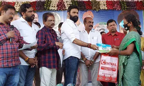 Civil Supplies Minister Kodali Nani handing over the house site patta to a beneficiary at a programme held in Gudivada rural mandal on Friday