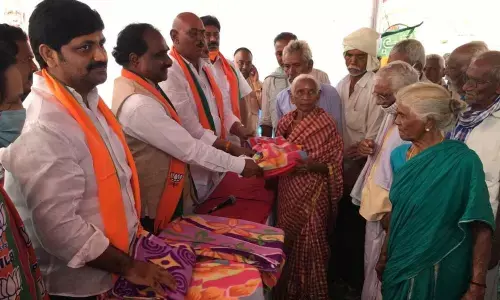 BJP leaders distributing blankets to old people as part of Vajpayees birth anniversary celebrations in Pelluru village on Friday