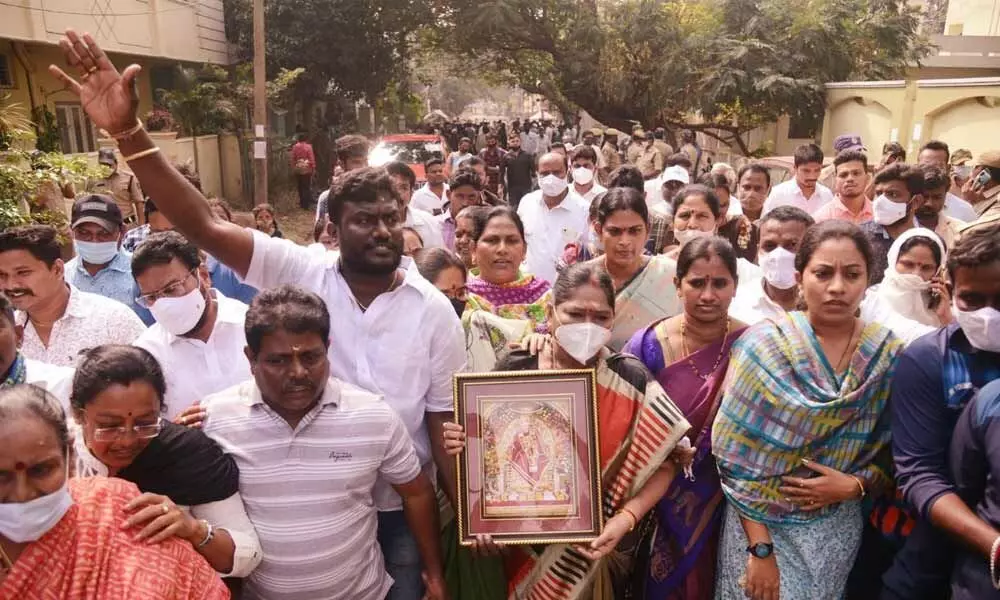 YSRCP leader Akkaramani Vijaya Nirmala carrying the portrait of Saibaba in response to the challenge thrown by MLA V Ramakrishna Babu in Visakhapatnam on Saturday