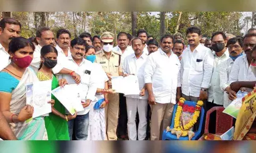 Jaggampeta MLA Jyothula Chantibabu distributing house site pattas to beneficiaries at Pentapalli on Monday