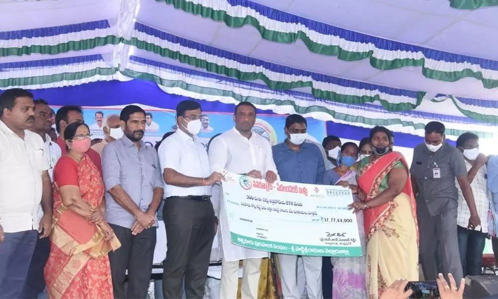 Minister for IT, Industries and Skill Development Mekapati Goutham Reddy handing over house site patta to a beneficiary in Atmakur on Wednesday. Collector K V N Chakradhar Babu is also seen