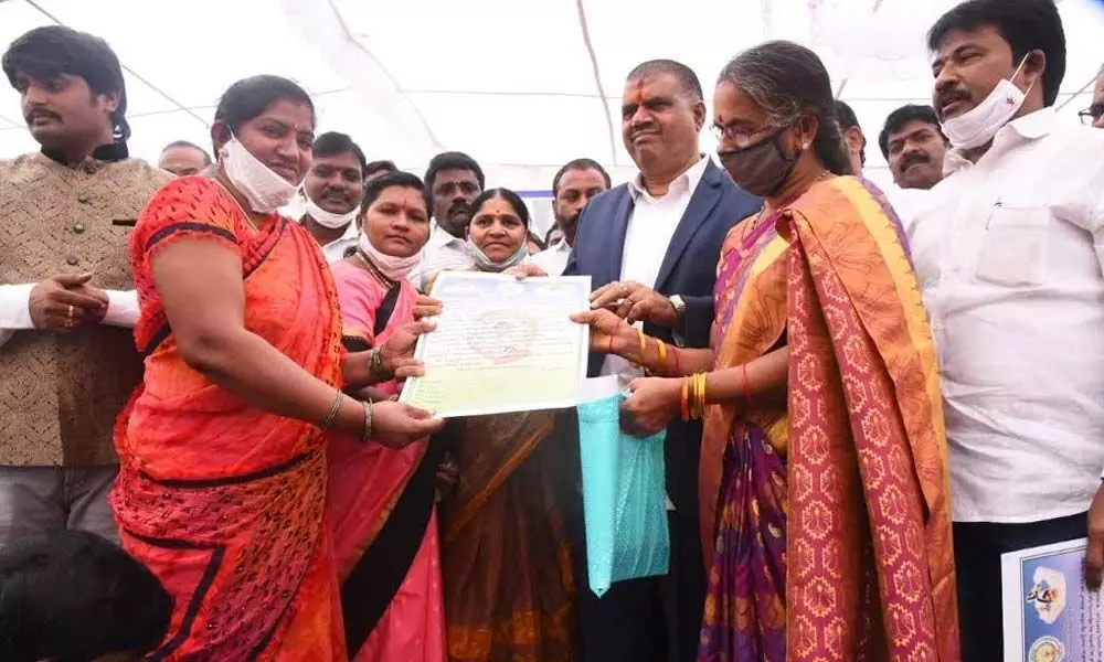 Tourism Minister Muttamsetti Srinivasa Rao distributing house site pattas to beneficiaries at Simhachalam on Friday