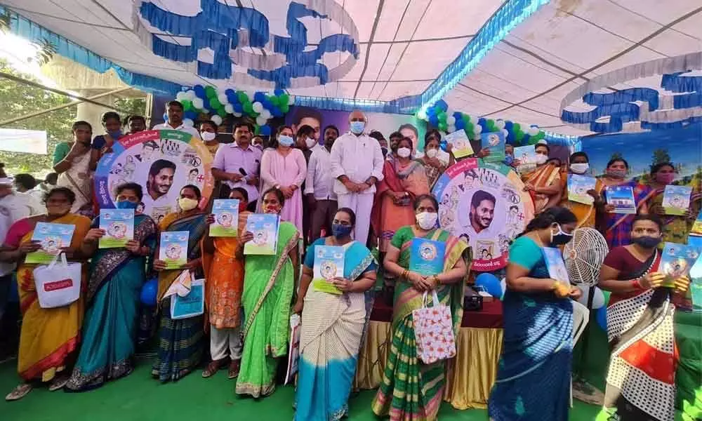 Vijayawada Central MLA Malladi Vishnu with the beneficiaries of the house site pattas at R K Puram on Saturday