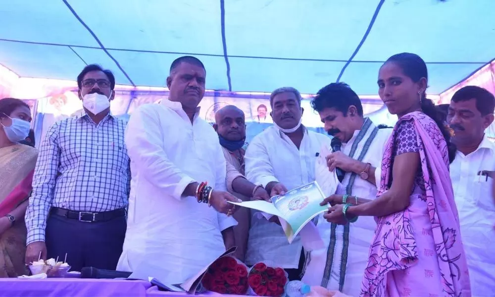 Tourism Minister M Srinivasa Rao distributing house sites to the beneficiaries at Chodavaram constituency in Visakhapatnam district on Monday