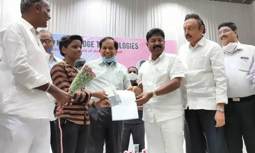 Education Minister Audimulapu Suresh handing over admission papers to a student after launching counselling for admissions into IIIT courses at Nuzvid on Monday