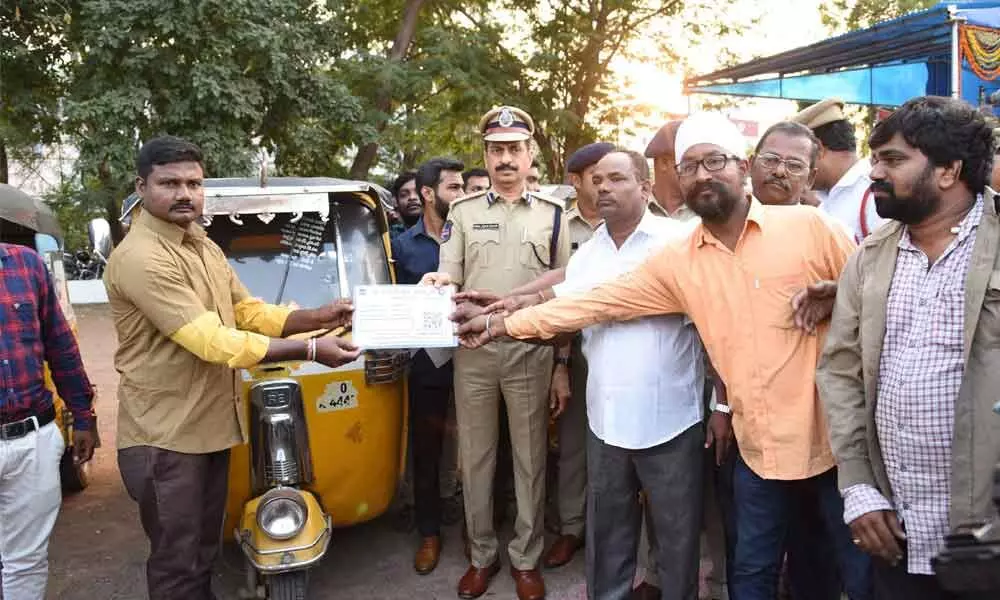 Police Commissioner VB Kamalasan Reddy allotting QR code to a auto in Karimnagar on Tuesday