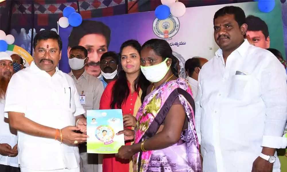 Endowments Minister Velampalli Srinivas distributing house site pattas to the beneficiaries in Vijayawada on Tuesday