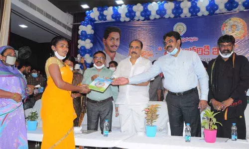 Minister Balineni Srinivasa Reddy and Collector Pola Bhaskara distributing housing plots in Ongole on Wednesday