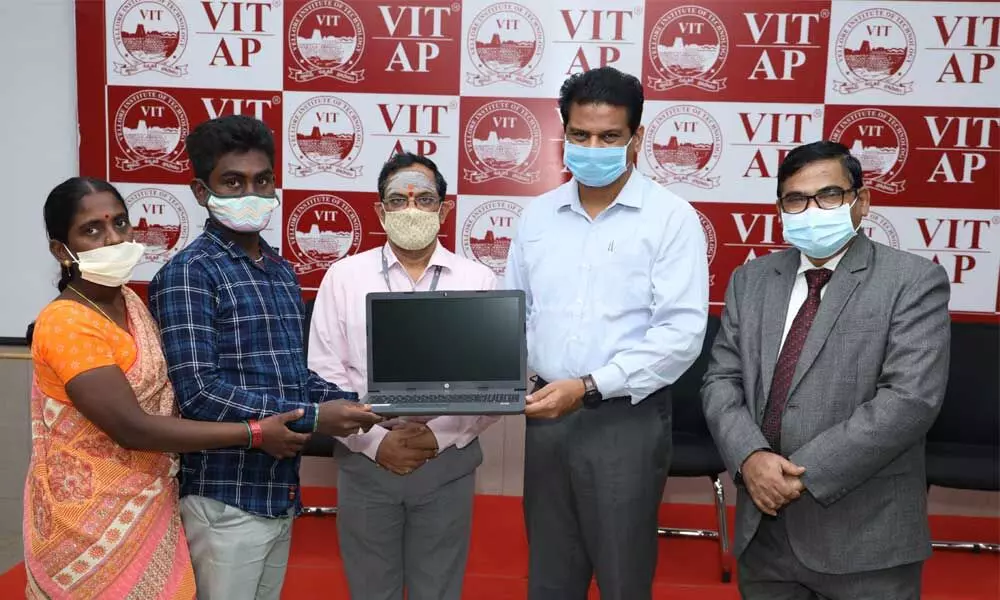 Dr Sekar Viswanathan handing over a laptop to one of the STARS student at VIT-AP University in Amaravati on Friday