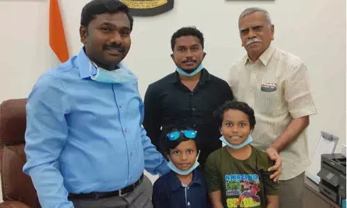 Kadapala Sankar with his daughter Kadapala Ritwika Sree (in green dress) with District Collector Gandham Chandrudu