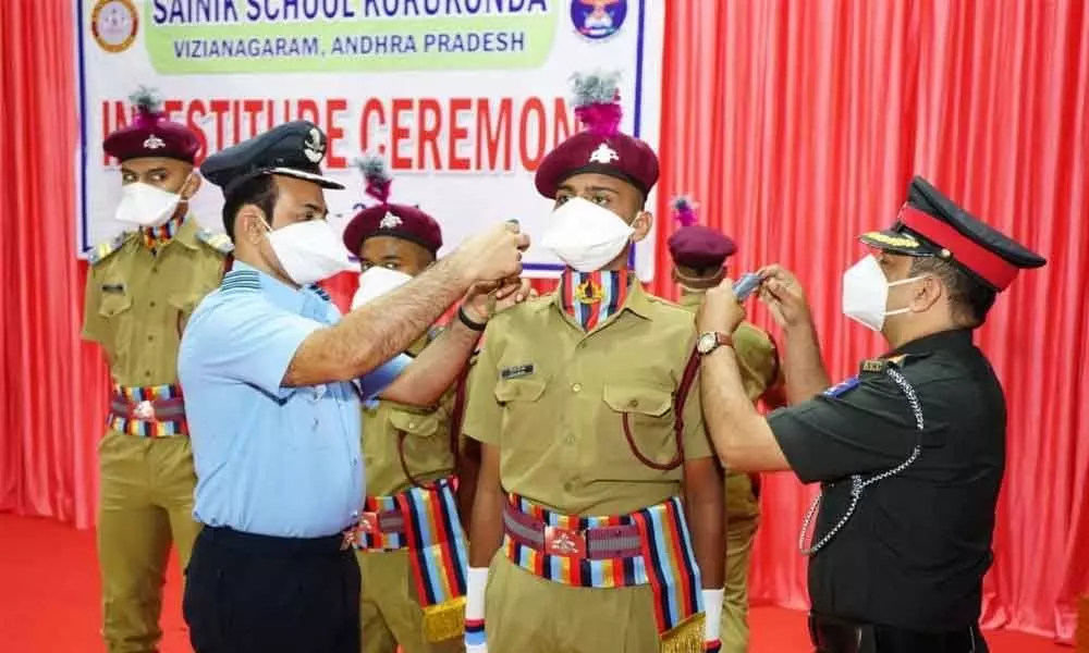 Colonel Arun M Kulkarni presenting badges to the cadets of Korukonda Sainik School