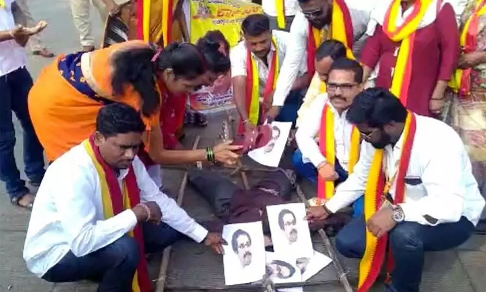 Pro-Kannada protesters hitting a photograph of Uddhav Thackeray with slippers  on Monday