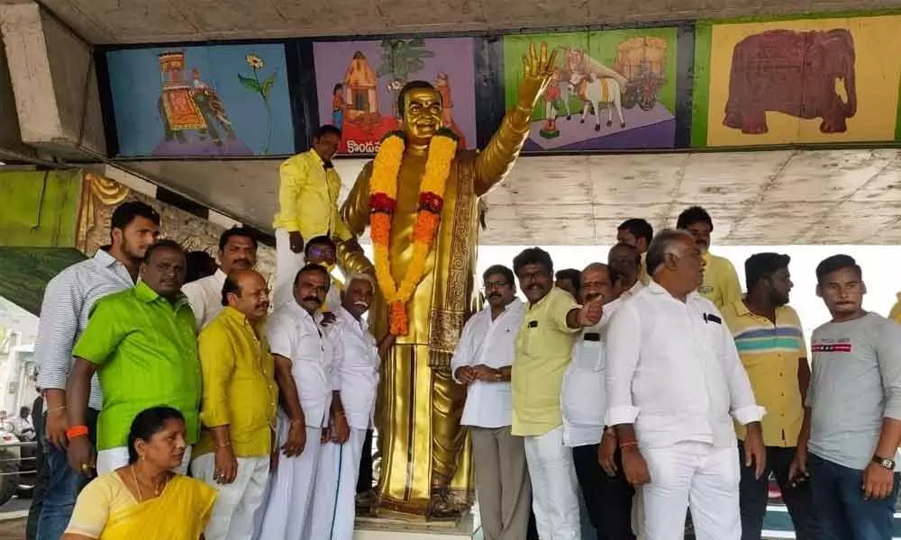 TDP leaders garlanding the statue of NTR at the Kurnool road flyover in Ongole on Monday