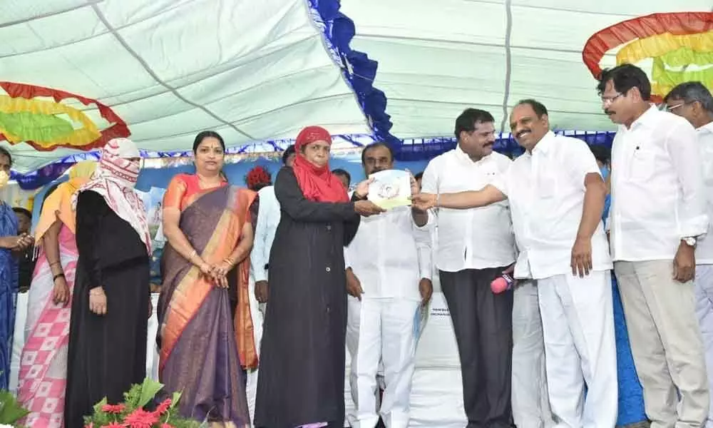 District in-charge Minister Botcha Satyanarayana and Minister for Roads and Buildings Sankara Narayana giving away house site patta to a beneficiary at Upparapalle village in Anantapur on Monday