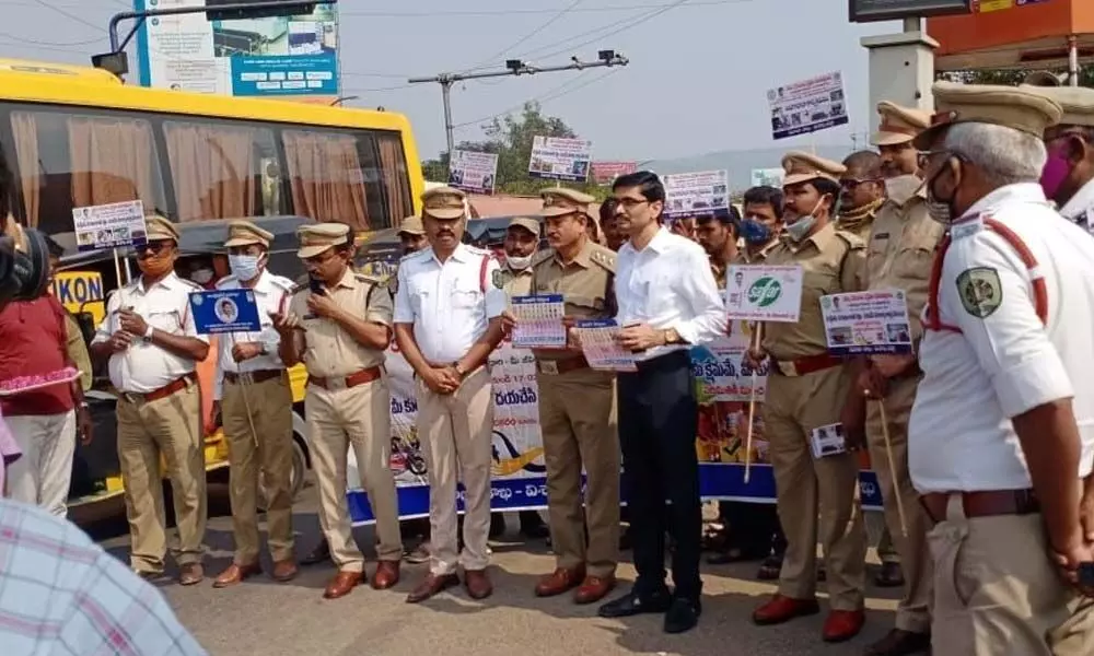 Deputy Transport Commissioner GC Raja Ratnam and other officials and cops displaying placards to create awareness on road safety at Maddilapalem junction in Visakhapatnam on Tuesday