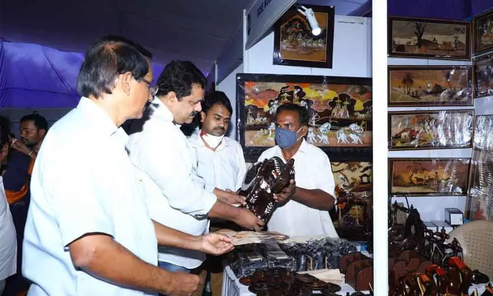 TUDA Vice-Chairman S Harikrishna and Shilparamam CEO S Jayaraj interacting with an artisan at Gandhi Shilp Bazaar in Tirupati on Friday.
