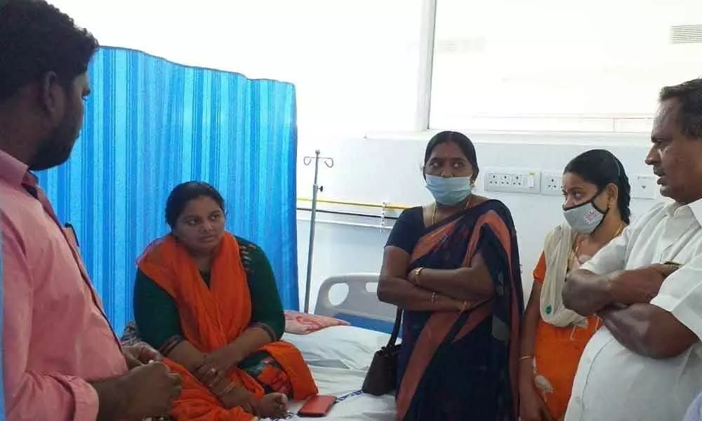 CPM Guntur East secretary Pasam Rama Rao consoling Anganwadi worker Deepti and ANM Lakshmi undergoing treatment at GGH for adverse impact of Covidshield vaccine in Guntur on Sunday