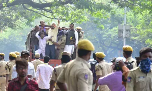 Police official arresting minority people as they are protesting for  re-constructing of Masjid in Secretariat, in Hyderabad on Sunday