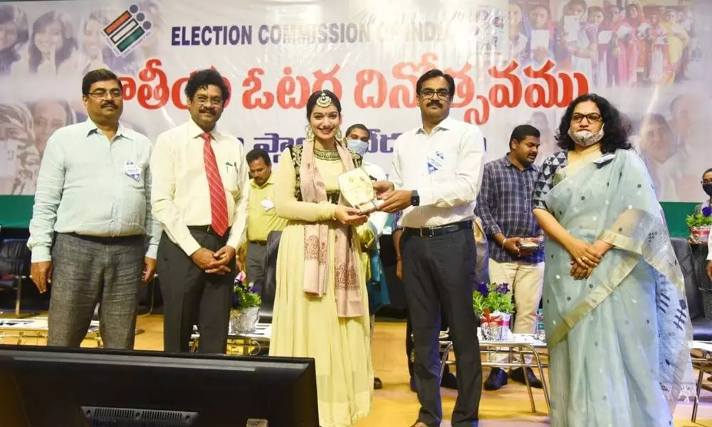Joint Collector M Venugopal Reddy presenting a memento to an artiste at the National Voters Day celebrations in Visakhapatnam on Monday. GVMC Commissiner G Srijana and others are seen.