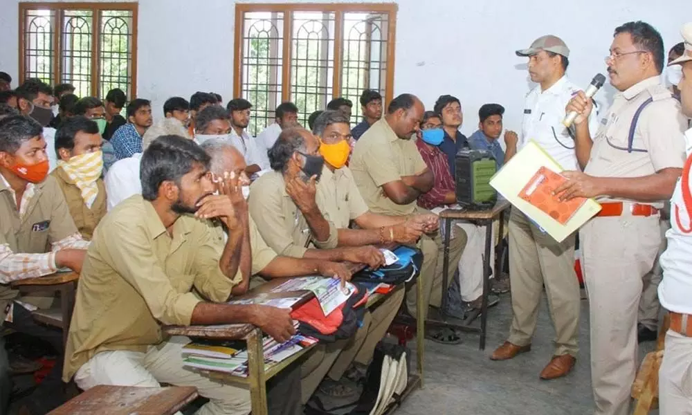 Traffic DSP K Venugopal creating awareness on road safety guidelines to students and bus drivers at Harshini Degree College in Ongole on Monday