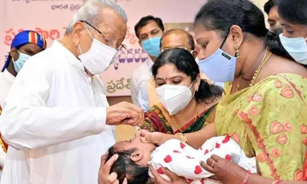 Governor Biswa Bhusan Harichandan administering polio drops to an infant at the Raj Bhavan in Vijayawada on Sunday