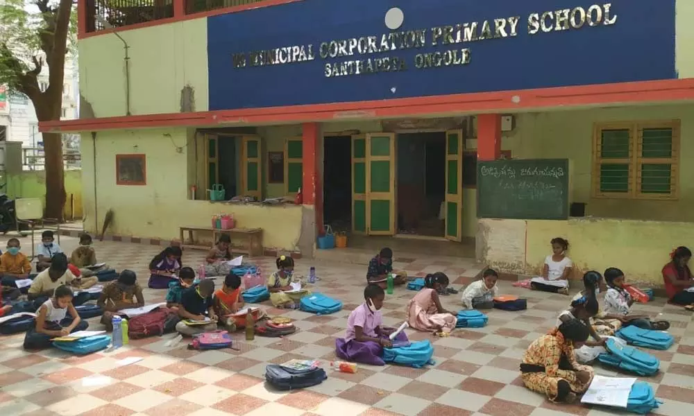 Students at a Municipal Primary School sit under sun as the classrooms are not ready, in Ongole on Monday