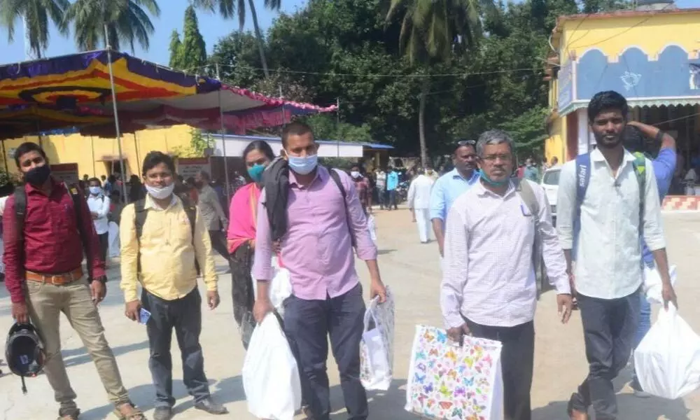 Election staff carrying material at a polling station for gram panchayat elections in Srikakulam on Monday