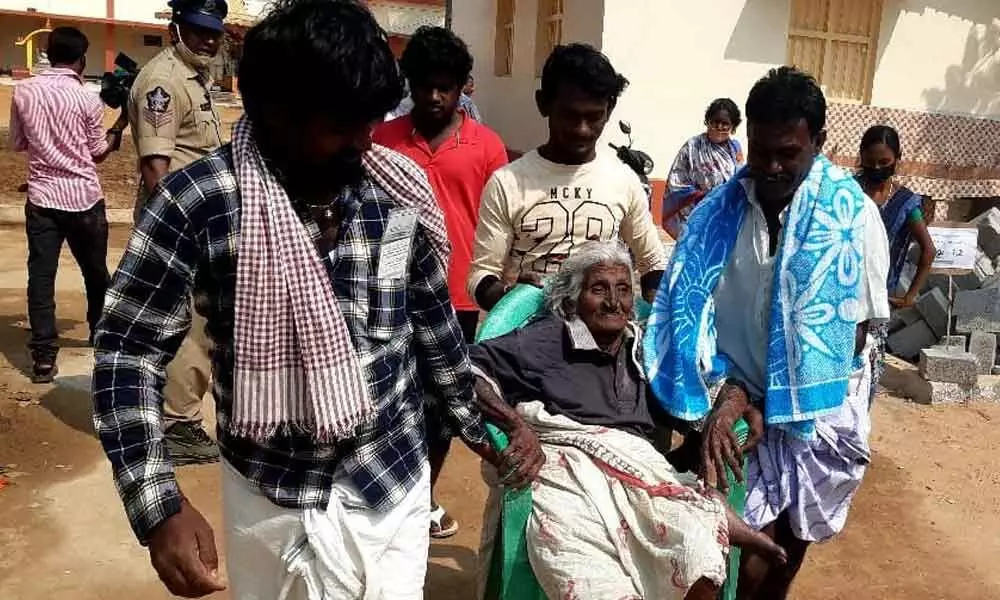 86-year-old woman K.Ramanamma being taken to a polling station at Murapaka village in Laveru mandal in Etcherla Assembly constituency in Srikakulam district on Tuesday