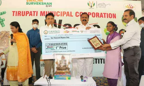 MLA Bhumana Karunakar Reddy and MCT Commissioner P S Girisha giving Rs 10,000 cheque to first prize winner P Munikumari of MCH School
