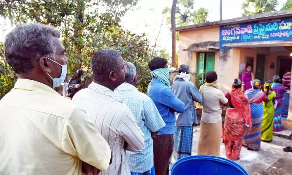 Voters  stand in ququeline for voting in Pamarru village of Krishna district.