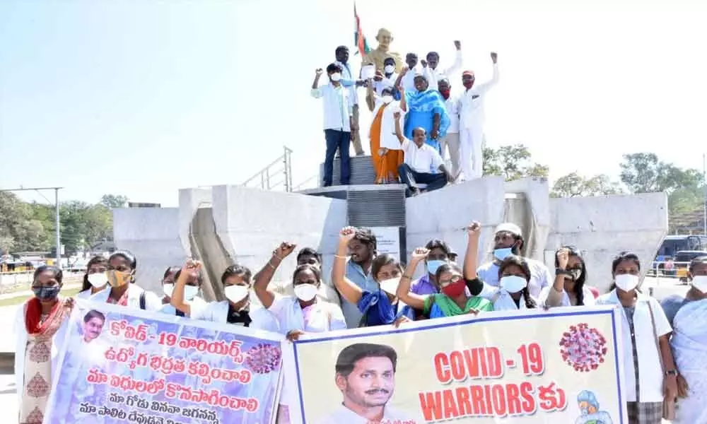 Covid-19 warriors staging a dharna at Gandhi statue in Chittoor on Saturday