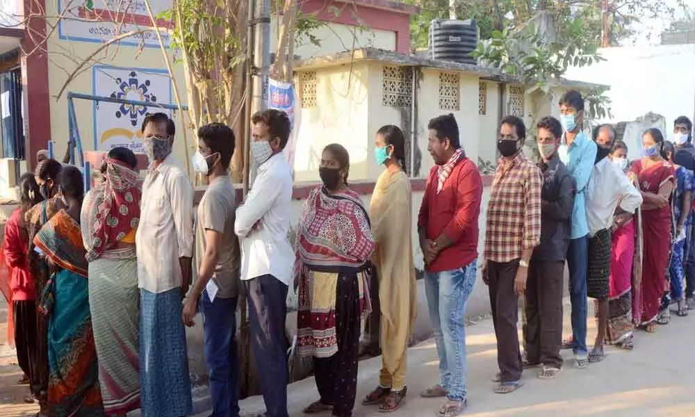 Voters stand in queue line to cast votes in Phase-2 panchayat election polling at Korukonda in East Godavari district on Saturay