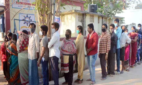 Voters stand in queue line to cast votes in Phase-2 panchayat election polling at Korukonda in East Godavari district on Saturay