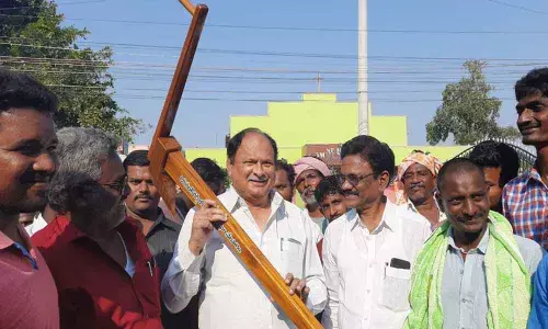Chirala MLA Karanam Balarama Krishnamurthy interacting with the owners of bullock carts while holding the plough presented by Oruganti Reddy Yuvajana Sangham at Chirala on Monday