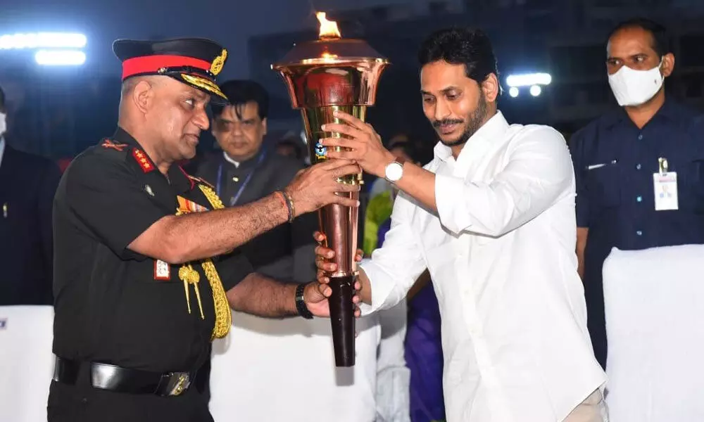 Chief Minister YS Jagan Mohan Reddy and Lt Gen A Arun carrying the Indo-Pak war victory flame on to the dais in Tirupati on Thursday