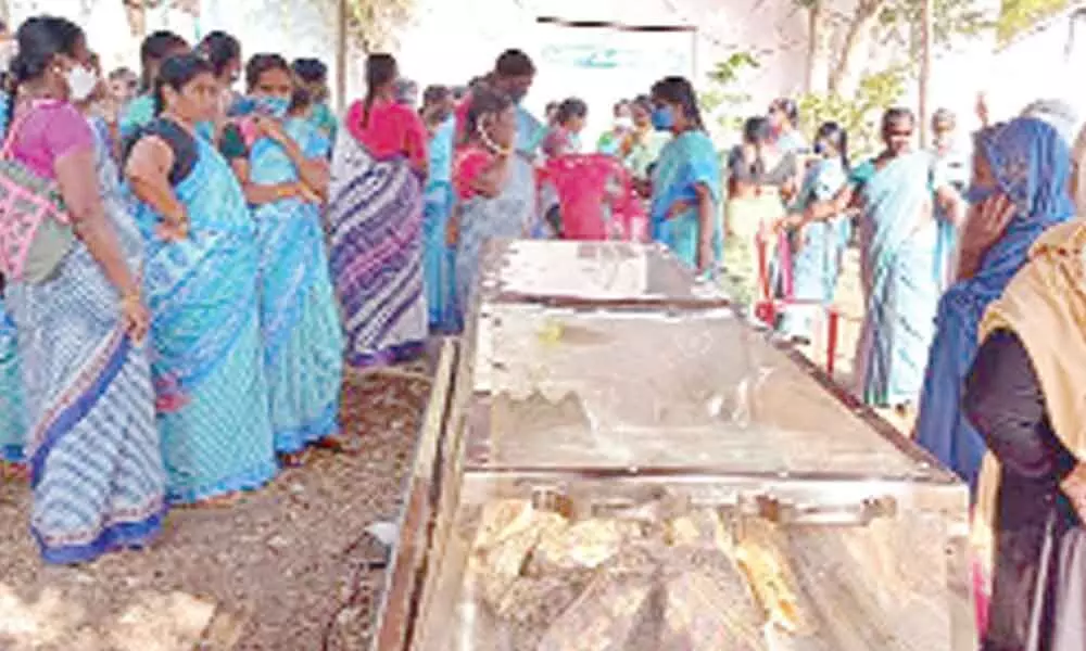 Anganwadi helpers staging a protest with the body of Noor Jahan in front of CPDO office in Nandikotkur on Monday