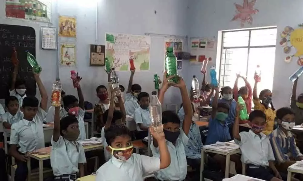 Students attend school with water bottles in view of Covid fears, at GNR Municipal Corporation Elementary School at Ramarajya Nagar in Vijayawada