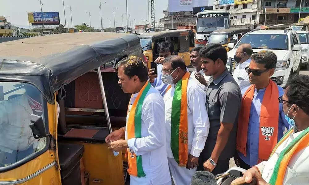 Rajya Sabha member G V L Narasimha Rao interacting with an auto-rickshaw driver and taking his feedback on the NAD flyover in Visakhapatnam on Thursday. 	Photo: Vasu Potnuru.