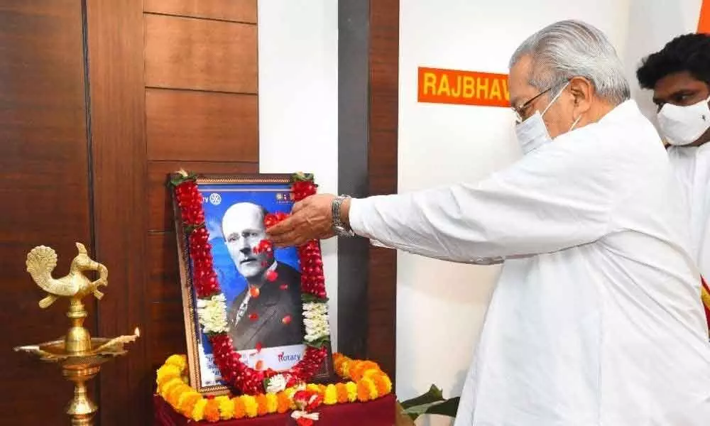 Governor Biswa Bhusan Harichandan paying floral tributes to the portrait of  Paul P Harris, founder of the Rotary Club in Vijayawada on Friday