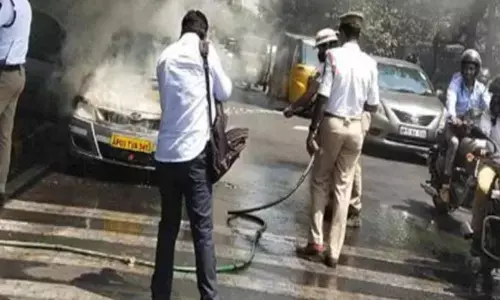 A moving car caught on fire here on Telugu Talli flyover on Monday morning in Hyderabad